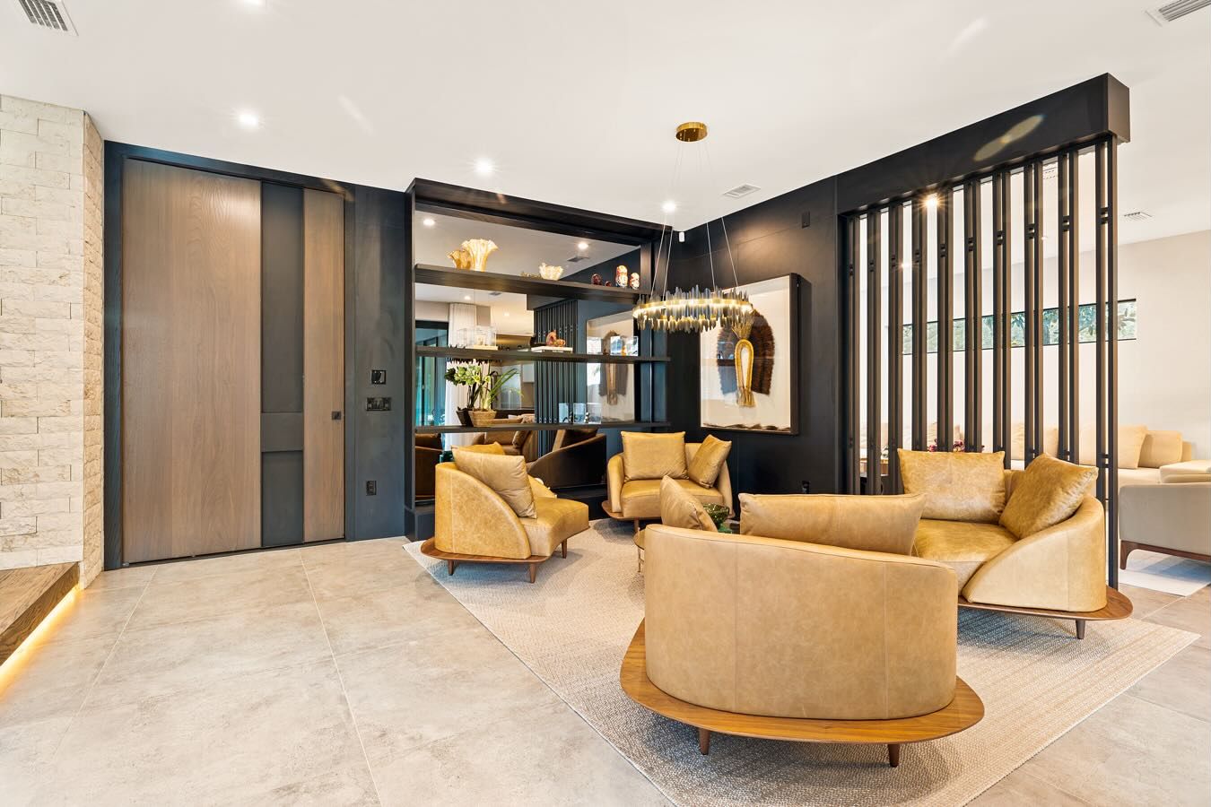 Open living area with wood slat divider and dark panels